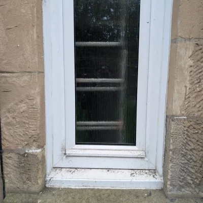 Close-up of dirty, deteriorating external window sill and frame before professional restoration, showing wear and tear.