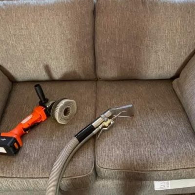 Close-up of professional equipment cleaning a large area rug with the upholstery tool, ensuring thorough saturation and extraction of embedded dirt.